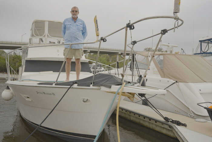Dave Fuller standing aboard boat at marina