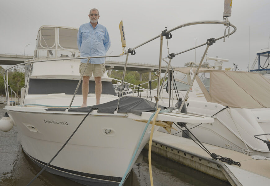 Dave Fuller standing aboard boat at marina
